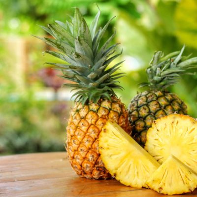 Sliced,half,And,Whole,Of,Pineapple(ananas,Comosus),On,Wooden,Table,With